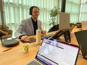 Jeroen Vonk met een headset op achter zijn laptop.