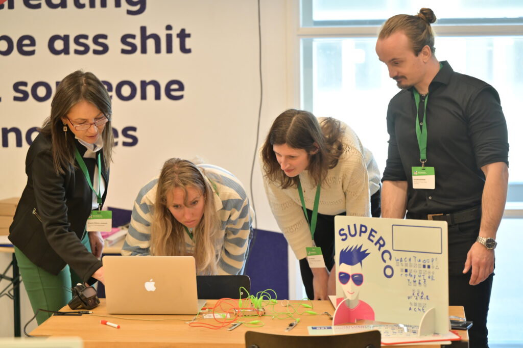 Een team met serieuze gezichten rond een laptop 